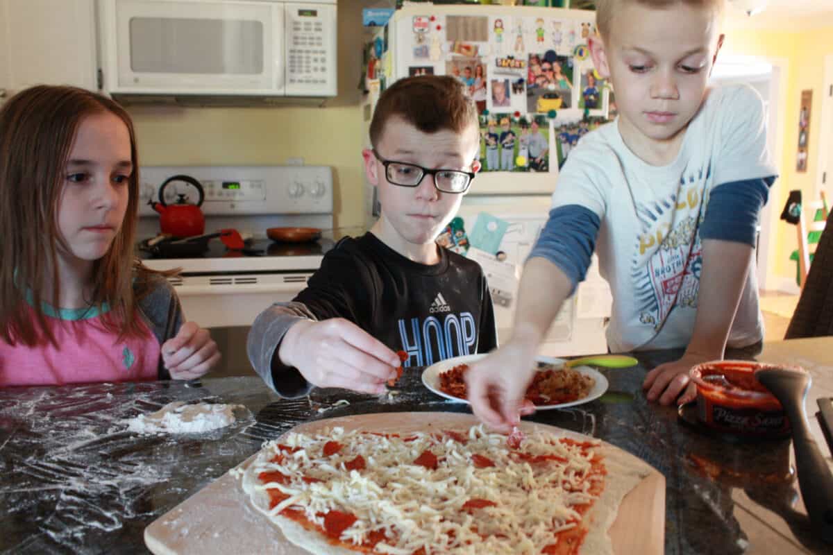 kids making pizza with fresh dough.
