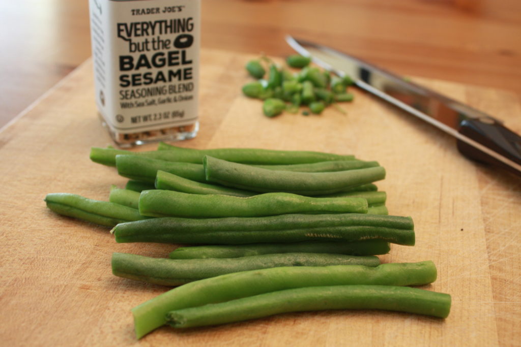 Trim and cut the green beans on a cutting board.