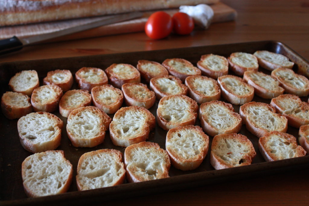 Toasted slices of bread on a baking sheet.