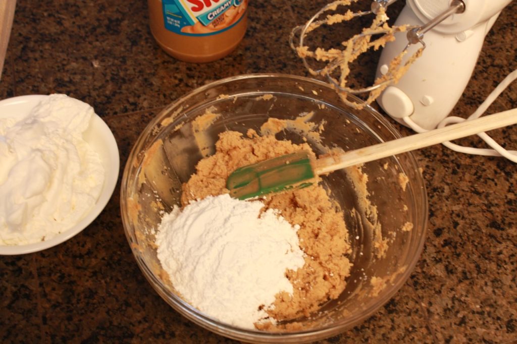 Adding powdered sugar to the mixture. 