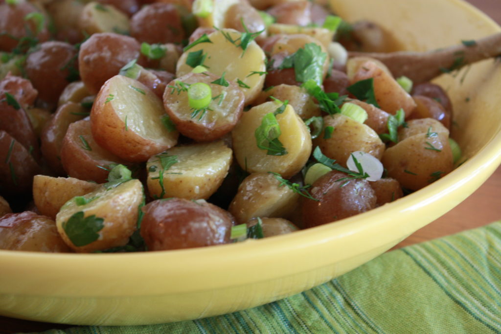 French Potato Salad ready to eat in a large yellow serving bowl