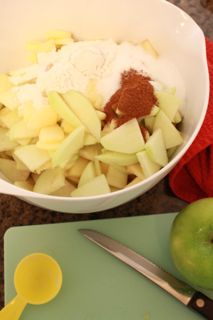 Bowl with apples cinnamon and other ingredients. 