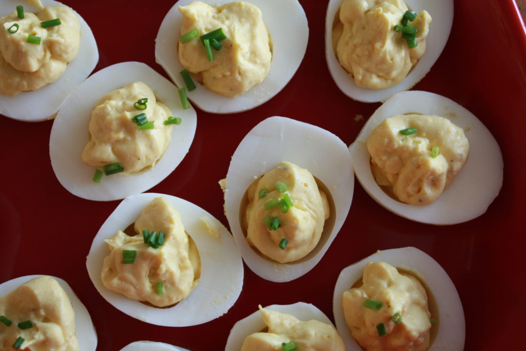 Looking down on deviled eggs with chives on top.