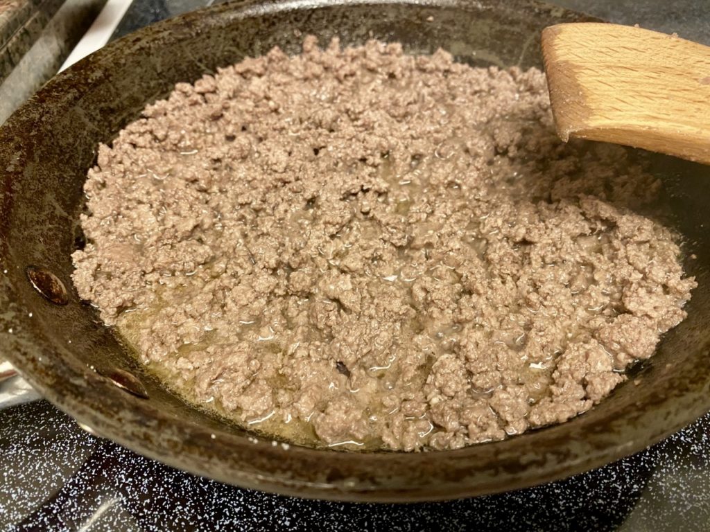 Skillet with cooked ground beef.