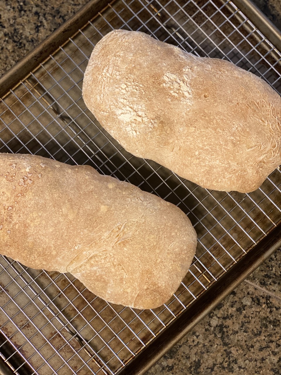Loaves of homemade ciabatta on a cooling rack.