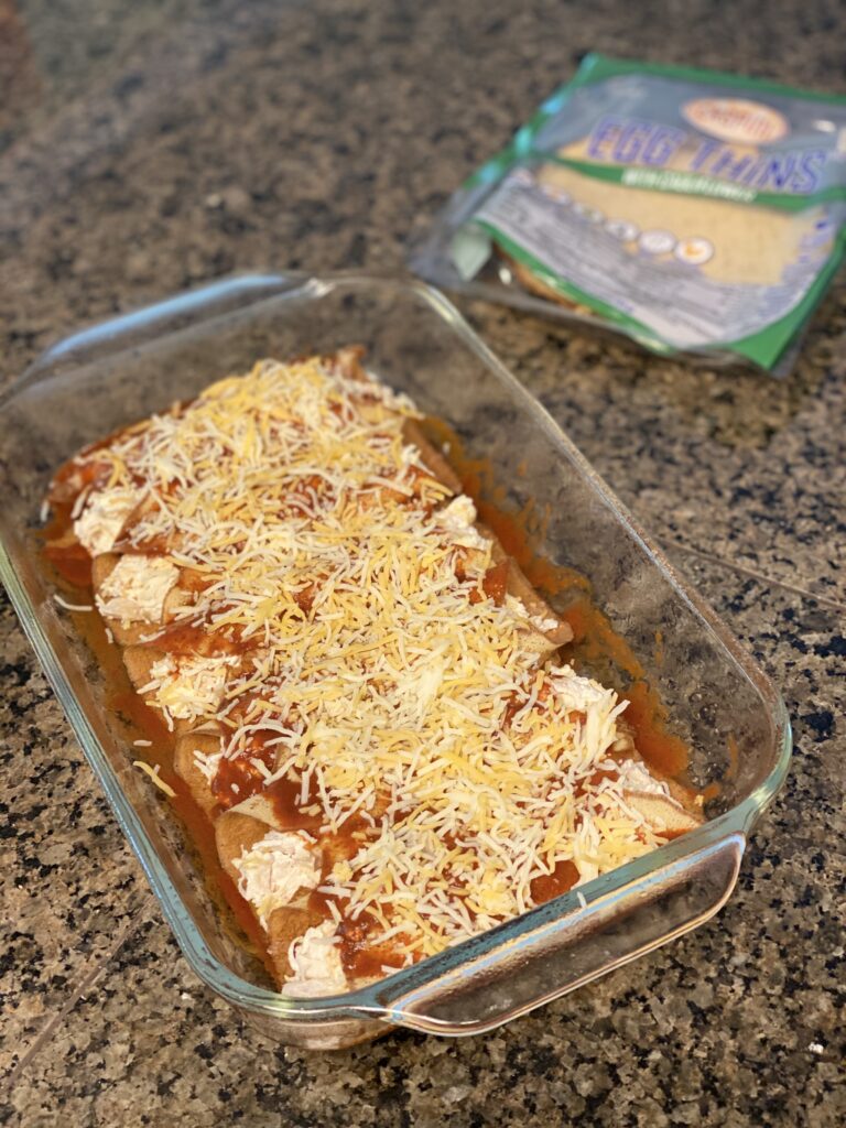 Keto Chicken enchiladas filled with cheese and topped with red sauce and cheese. 