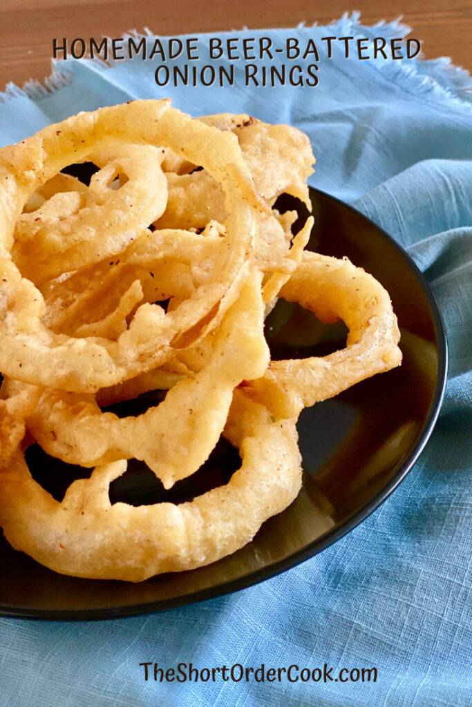 Homemade Deep-Fried Beer-Battered Onion Rings piled on a plate.