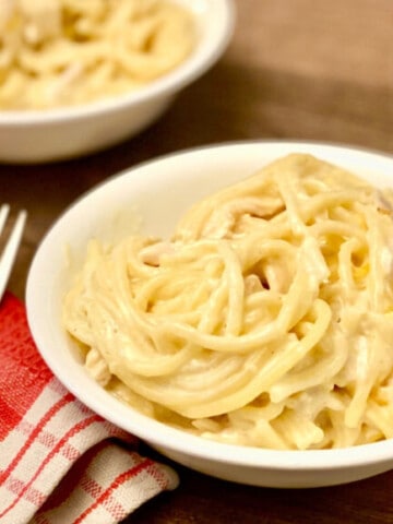 Instant Pot Creamy Chicken Spaghetti featured portrait with napkin and forks