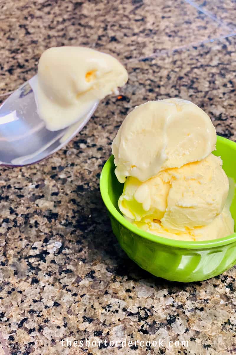 Best Ever Mango Ice Cream ready to eat with a bite on a spoon