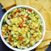 What to Serve with Coconut Shrimp pineapple-mango-salsa-recipe-caramelandcashews a bowl of mango salsa surrounded by chips