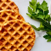 Keto Cornbread Chaffles featured 3 fanned chaffles on the left and right is a partial bowl of chili w parsley