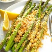 What to Serve with Lobster Roasted-Asparagus-Parmesan-8-650x975 lemonblossoms a white plate topped with roasted asparagus with parmesan crumbs atop and lemon wedges on the side