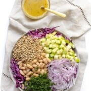 What to Serve with Lobster White-Bean-Cabbage-Slaw-with-Apples-Cider-Vinaigrette-683x1024 fantasticfood overhead shot of a large mixing bowl with all the ingredients in sections inlcuding beans, onions, apples, sunflower seeds and more