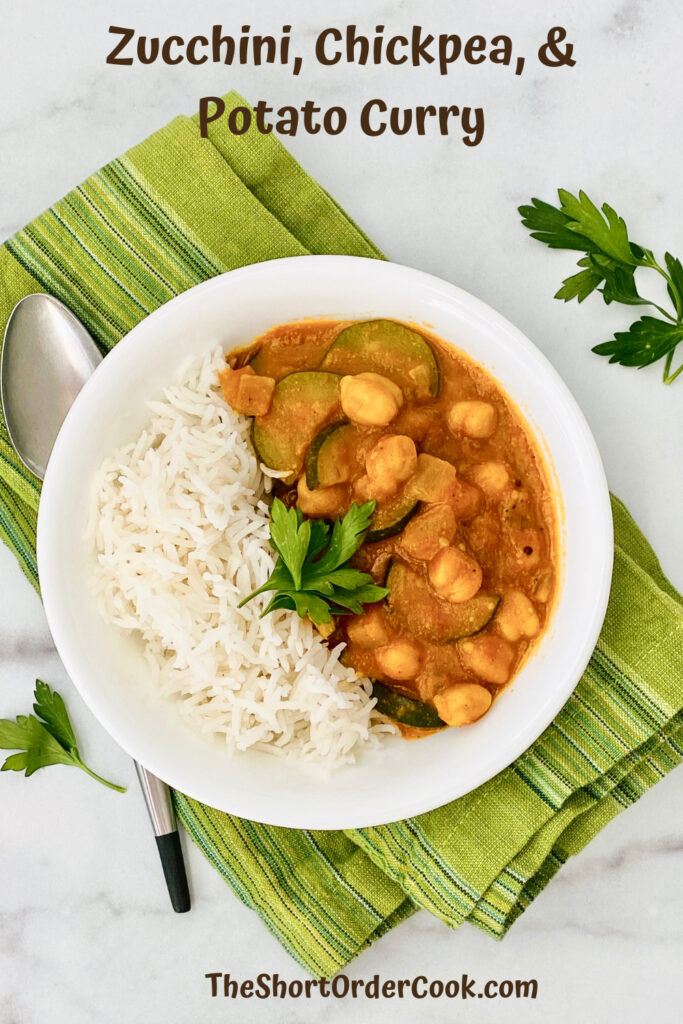 Zucchini, Chickpea, & Potato Curry PN1 overhead photo of a bowl of curry with rice along with green napkin, spoon, and parsley garnish