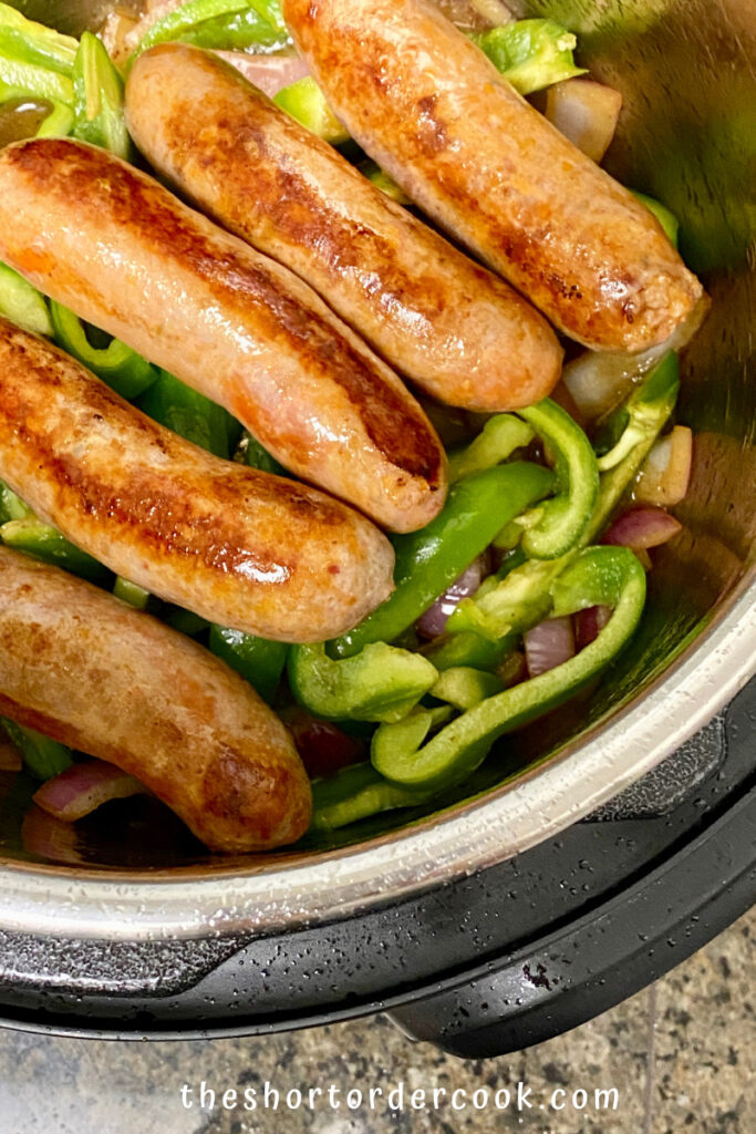 Instant Pot Italian Sausage & Peppers with sausages layered on top of the peppers and onions