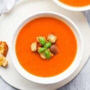 What to Serve with Sandwiches Easy-tomato-soup-7-650x975 littlesunnykitchen overhead photo of a white bowl with bright red tomato soup with a few croutons and herbs on top