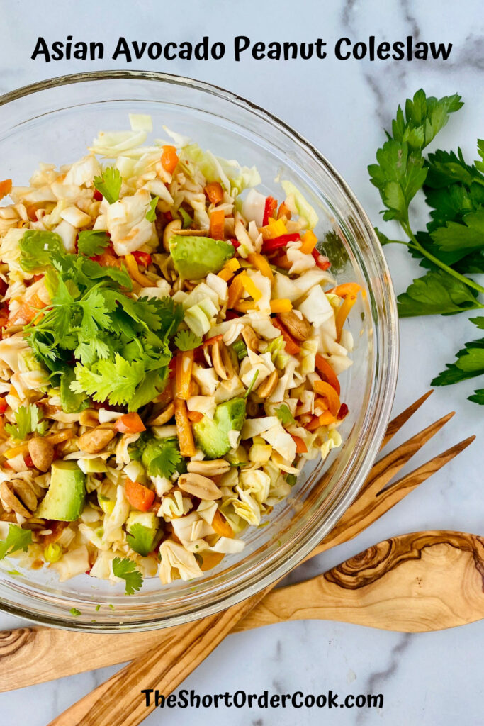 Asian Avocado Peanut Coleslaw PN1 overhead shot of serving bowl with coleslaw ready to eat and topped with cilantro and parsley to the side and wooden serving utensils