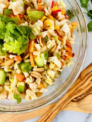 Asian Avocado Peanut Coleslaw featured closeup bowl with parsley and utensils on the bottom