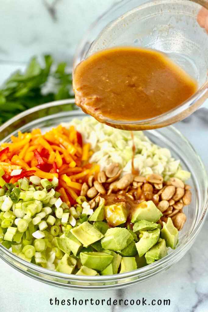 Asian Avocado Peanut Coleslaw pour the dressing on the salad ingredients