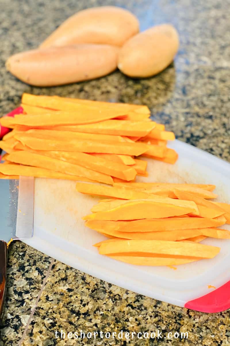 Deep Fried Sweet Potato Fries shoestring cut sweet potatoes on a cutting board