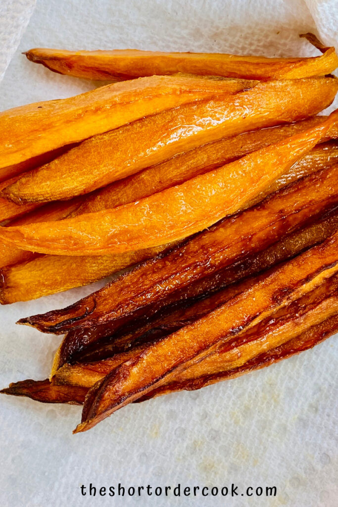 Deep Fried Sweet Potato Fries two batches of sweet potato fries on a paper towel lined dish one after the first fry and still bright orange and the second is brown after second fry