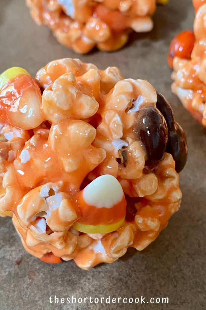 Halloween Popcorn Balls close-up of orange popcorn ball with m&ms and candy corn