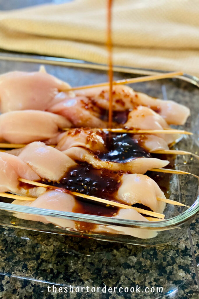 Teriyaki Chicken on a Stick pour teriyaki marinade over chicken on the sticks