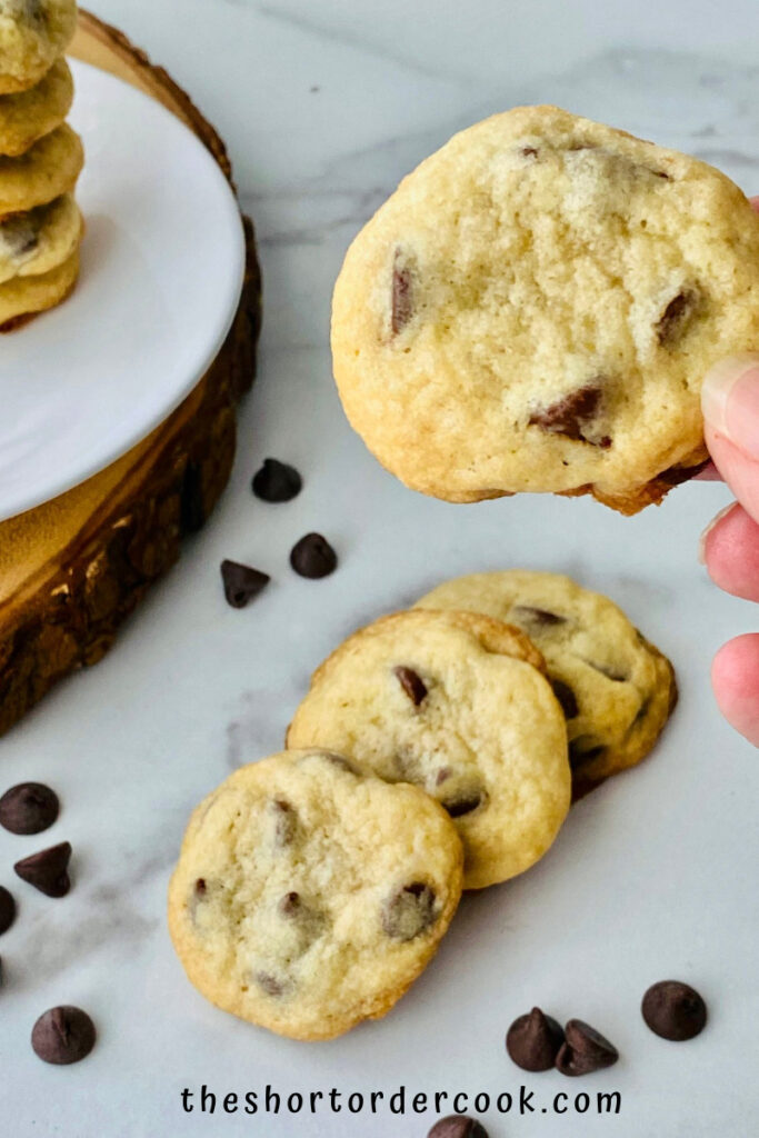 Chocolate Chip Cookies without Brown Sugar cookies ready to eat fanned on the marble counter and a hand holding one up close