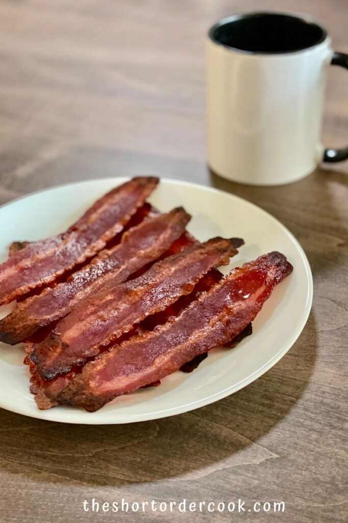 How to Cook Turkey Bacon in the Microwave Oven ready to eat on a plate with a mug in the background