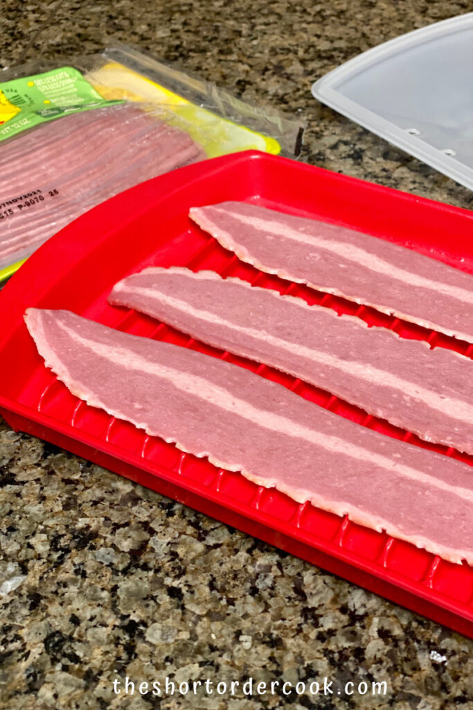 How to Cook Turkey Bacon in the Microwave Oven strips on a micrwave tray and an opened package of turkey bacon