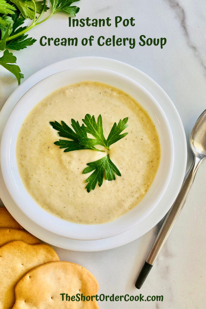 Instant Pot Cream of Celery Soup PN1 bowl of soup ready to eat with a bit of parsley on top and crackers ot the bottom with a soup spoon to the right