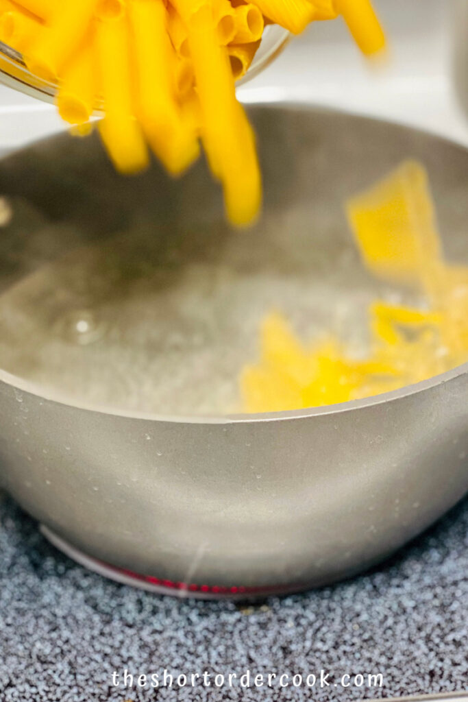 Rigatoni pasta being added to boiling water