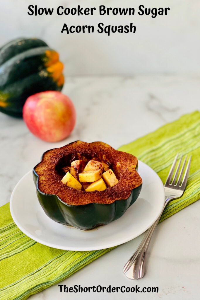 Slow Cooker Brown Sugar Acorn Squash PN1 plated half an acorn squash cut open cooked stuffed with apples and an acorn squash and apple in the background