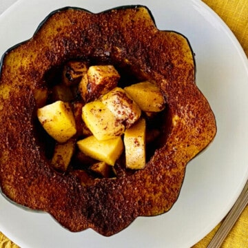 Slow Cooker Brown Sugar Acorn Squash featured overhead of apple cinnamon stuffed squash on a plate