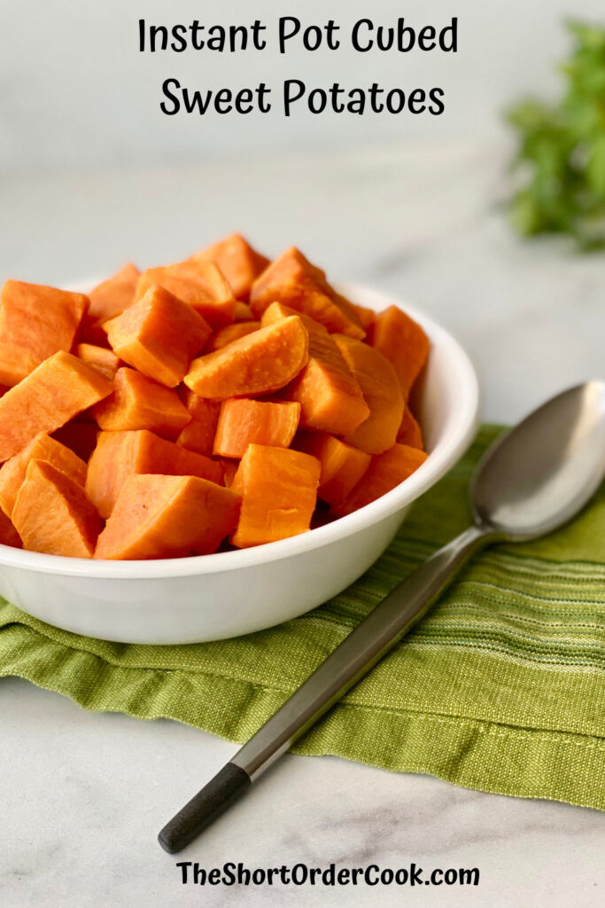 Instant Pot Cubed Sweet Potatoes PN1 a bowl filled with cooked sweet potato cubes plus a spoon and green napkin