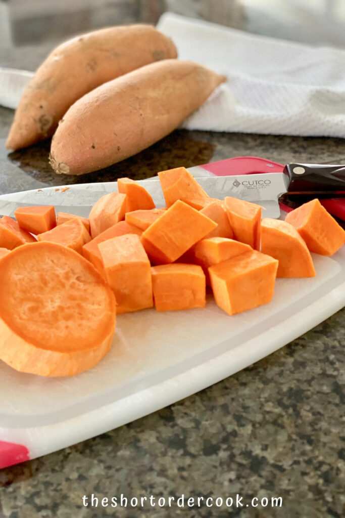 Instant Pot Cubed Sweet Potatoes cutting board with knife and some cubed sweet potatoes