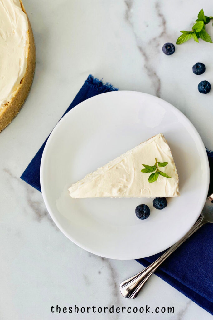 Keto No-Bake Cheesecake plated with whole cheesecake in the background