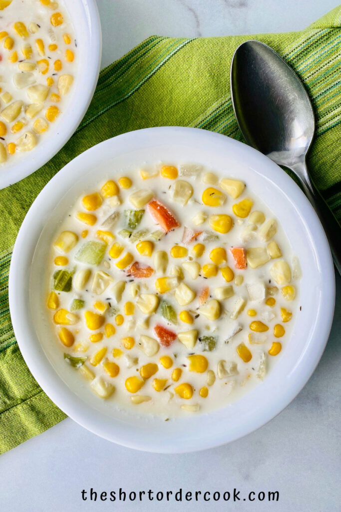 Slow Cooker Chicken & Corn Soup ready to eat in bowls with a cloth napkin and spoon