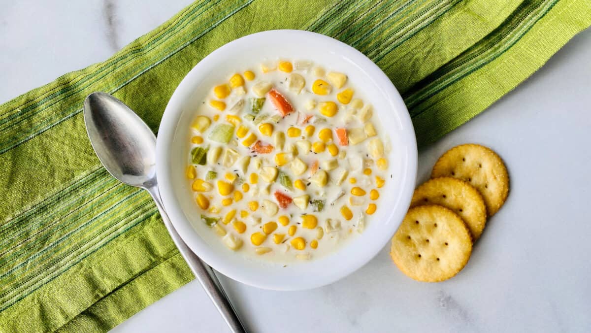 Slow Cooker Chicken & Corn Soup recipe card bowl of soup and crackers