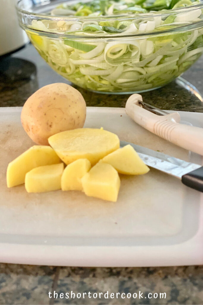 Slow Cooker Potato Leek Soup diced potatoes on a cutting board and bowl of soaking cut leeks