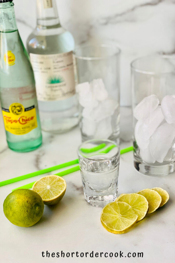 Texas Ranch Water 2 glasses filled with ice and otehr ingredients including sliced limes tequila and mineral water