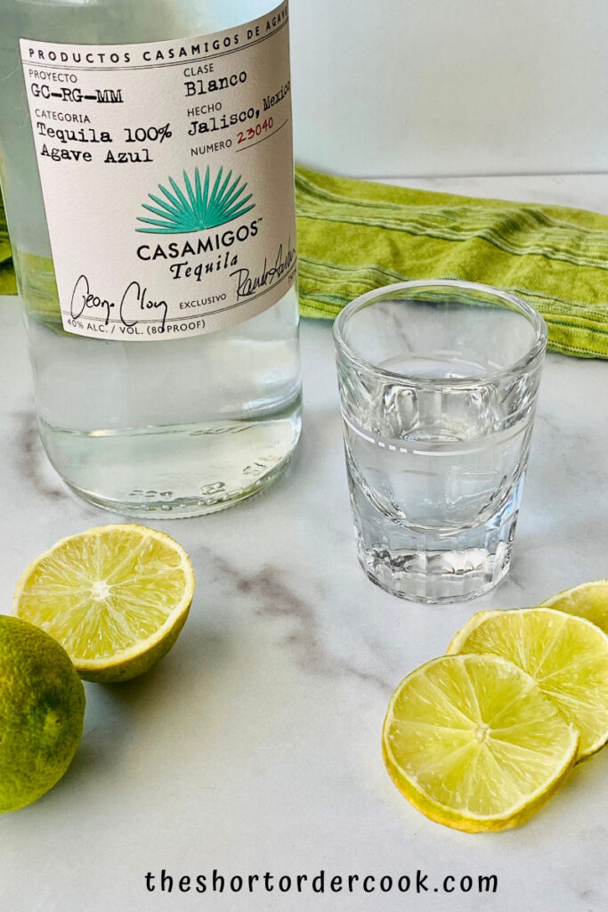 Texas Ranch Water tequila shot poured and sliced limes with Casamigos tequila bottle in the background