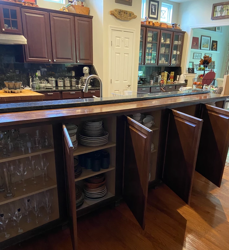 a kitchen counter with cabinets open showing everything stored
inside