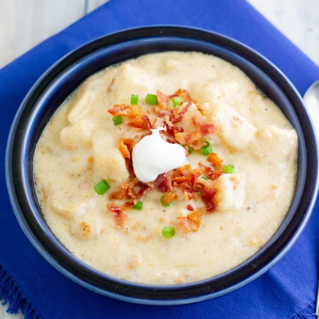 OVERHEAD image of a bowl filled with creamy white potato souptopped with bacon and sour cream