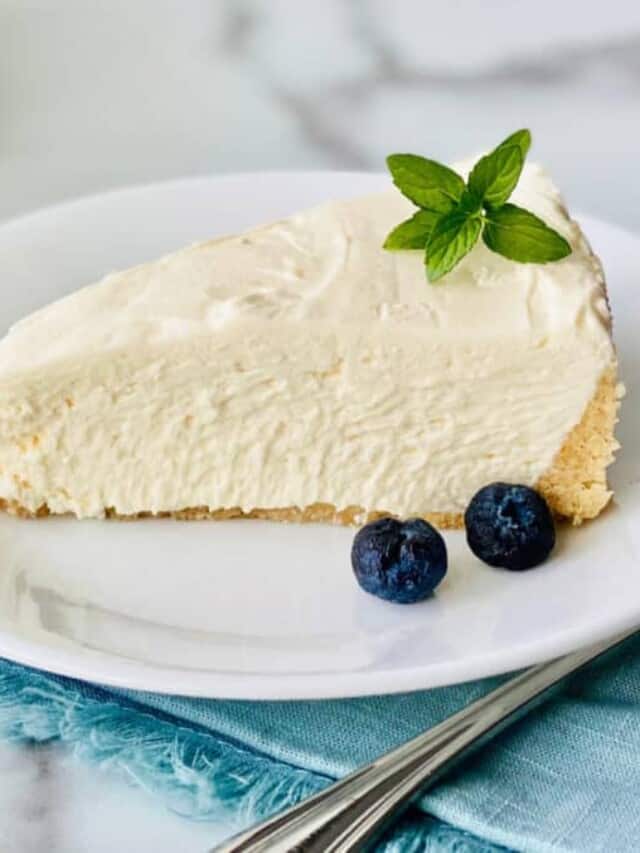 cropped-Keto-No-Bake-Cheesecake-recipe-card-slice-on-a-plate-with-mint-and-blueberries-fork-and-napkin-and-whole-cheesecake-in-the-background-e1634934186603.jpg