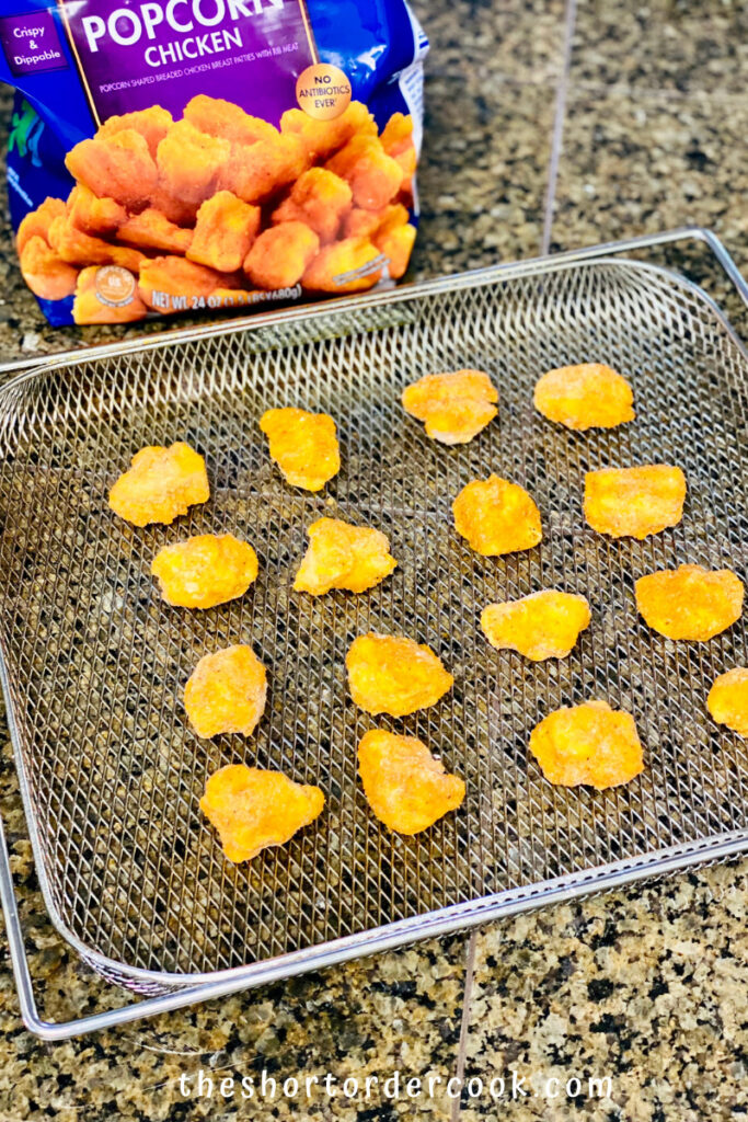Air Fryer Popcorn Chicken frozen spaced on the air fryer tray ready to be cooked
