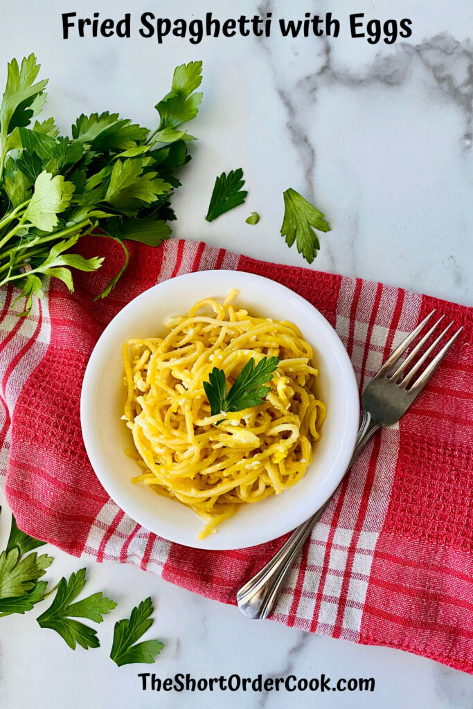 Fried Spaghetti with Eggs bowl of pasta with parsley and a red checked napkin