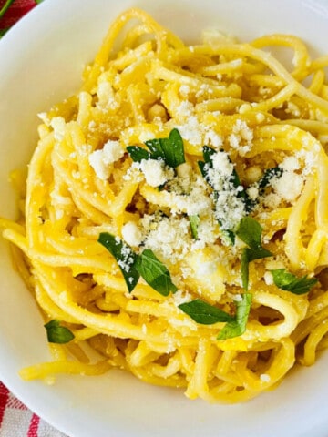 Fried Spaghetti with Eggs featured closeup overhead of bowl filled and topped with parmesan and parsley