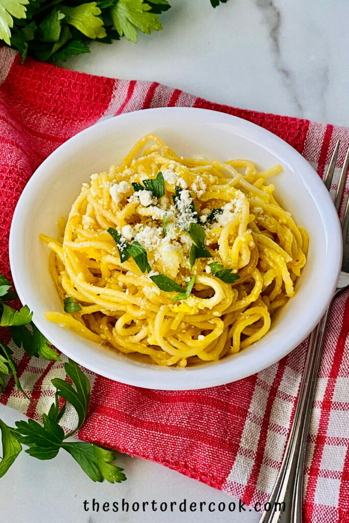 Fried Spaghetti with Eggs plated and ready to eat topped with parmesan cheese and fresh parsley