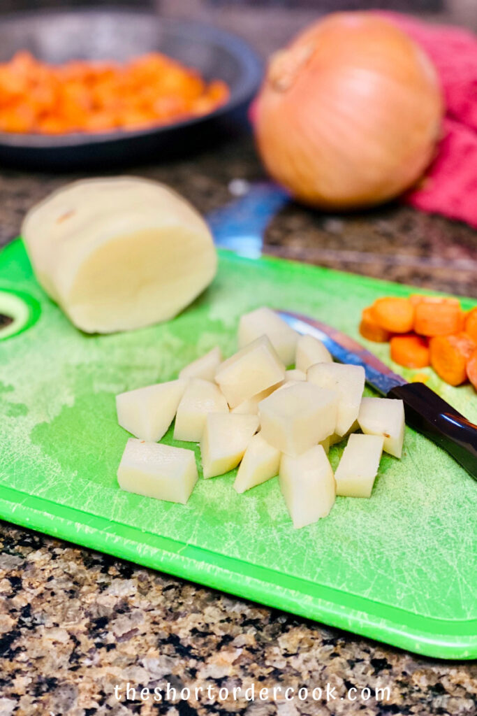 Slow Cooker Hungarian Goulash cutting board with diced vegetables